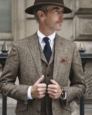 Come indossare e abbinare una cravatta blu per un uomo di 60 anni in estate 2024: Abbina un abito a tre pezzi marrone con una cravatta blu per essere sofisticato e di classe. Ideale per i mesi estivi, ovviamente!