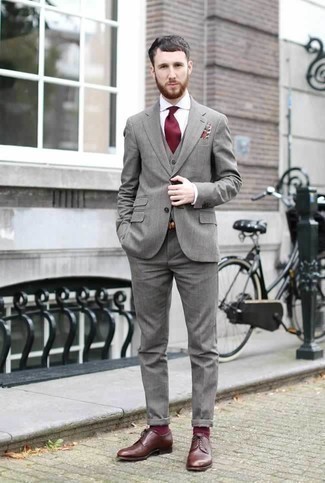 Come indossare e abbinare calzini rossi per un uomo di 30 anni in modo formale: Scegli un abito a tre pezzi grigio e calzini rossi per affrontare con facilità la tua giornata. Prova con un paio di scarpe derby in pelle marroni per dare un tocco classico al completo.