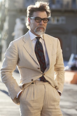 Come indossare e abbinare una cravatta per un uomo di 50 anni in estate 2024: Indossa un abito beige con una cravatta come un vero gentiluomo. Ecco un look perfetto per l’estate.