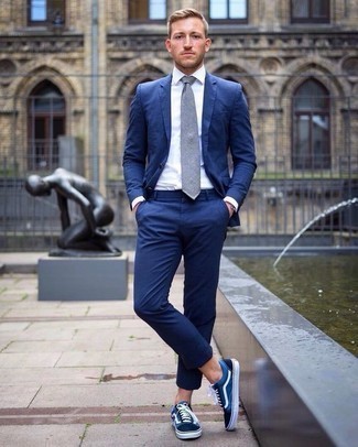 Come indossare e abbinare una cravatta grigio scuro con un abito blu: Metti un abito blu e una cravatta grigio scuro per un look elegante e alla moda. Se non vuoi essere troppo formale, opta per un paio di sneakers basse di tela blu scuro e bianche.