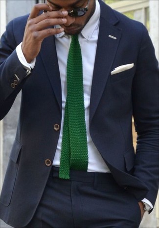 Come indossare e abbinare una cravatta lavorata a maglia verde quando fa caldo: Opta per un abito blu scuro e una cravatta lavorata a maglia verde per un look elegante e di classe.