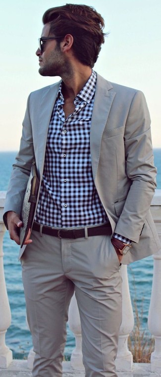 Come indossare e abbinare un abito grigio con una cintura in pelle marrone per un uomo di 30 anni: Abbina un abito grigio con una cintura in pelle marrone per un look trendy e alla mano.