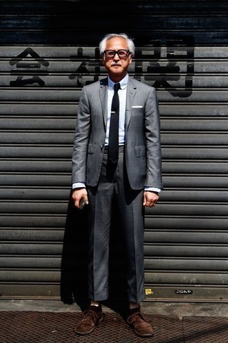 Come indossare e abbinare una cravatta per un uomo di 60 anni: Prova a combinare un abito grigio scuro con una cravatta per essere sofisticato e di classe. Per un look più rilassato, opta per un paio di chukka in pelle scamosciata marrone scuro.