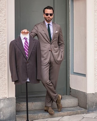 Trend da uomo 2021: Coniuga un abito marrone con una camicia elegante bianca per un look elegante e alla moda. Indossa un paio di chukka in pelle scamosciata verde oliva per un tocco più rilassato.