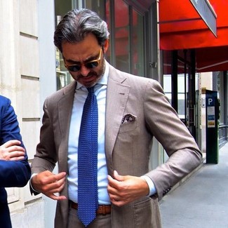 Come indossare e abbinare una cravatta blu per un uomo di 50 anni: Combina un abito marrone con una cravatta blu per un look elegante e di classe.