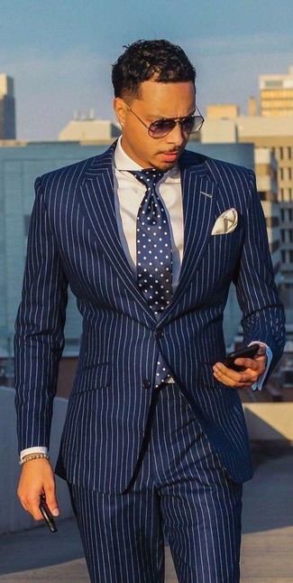 Come indossare e abbinare un bracciale beige per un uomo di 20 anni in modo formale: Per un outfit quotidiano pieno di carattere e personalità, indossa un abito a righe verticali bianco e blu scuro e un bracciale beige.