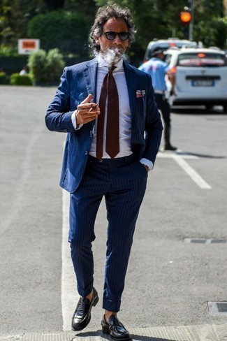 Come indossare e abbinare una cravatta rossa e blu scuro per un uomo di 40 anni: Abbina un abito a righe verticali blu scuro con una cravatta rossa e blu scuro per essere sofisticato e di classe. Se non vuoi essere troppo formale, opta per un paio di mocassini eleganti in pelle neri.