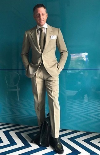 Moda uomo anni 40 in modo formale: Opta per un abito marrone chiaro e una camicia elegante bianca per essere sofisticato e di classe. Scegli un paio di mocassini eleganti in pelle verde scuro per un tocco più rilassato.