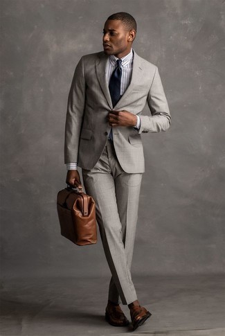 Come indossare e abbinare una cravatta di seta blu scuro: Scegli un abito grigio e una cravatta di seta blu scuro come un vero gentiluomo. Per un look più rilassato, opta per un paio di mocassini eleganti in pelle marroni.