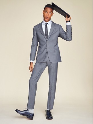 Look alla moda per uomo: Abito grigio, Camicia elegante bianca, Scarpe derby in pelle blu scuro, Pochette in pelle nera