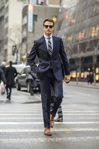 Come indossare e abbinare una cravatta per un uomo di 20 anni: Abbina un abito blu scuro con una cravatta per una silhouette classica e raffinata Prova con un paio di scarpe derby in pelle marroni per un tocco più rilassato.