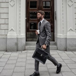 Come indossare e abbinare una borsa per un uomo di 30 anni in modo formale: Punta su un abito grigio e una borsa per un look spensierato e alla moda. Scarpe derby in pelle nere doneranno eleganza a un look altrimenti semplice.