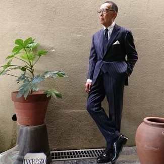 Moda uomo anni 60 in modo formale: Coniuga un abito a righe verticali blu scuro con una camicia elegante bianca per un look elegante e di classe.