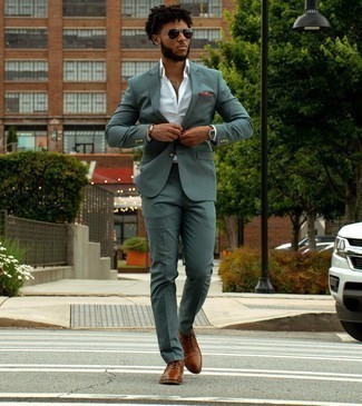 Come indossare e abbinare scarpe oxford marroni per un uomo di 20 anni in modo formale: Potresti combinare un abito verde scuro con una camicia elegante bianca come un vero gentiluomo. Completa questo look con un paio di scarpe oxford marroni.