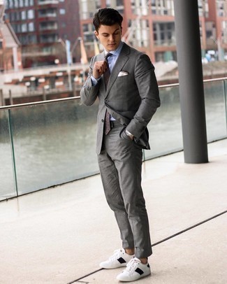 Come indossare e abbinare una cravatta marrone in modo smart-casual: Metti un abito grigio e una cravatta marrone per essere sofisticato e di classe. Per un look più rilassato, scegli un paio di sneakers basse in pelle bianche e nere.