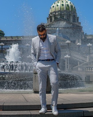 Quale camicia elegante indossare con sneakers basse bianche e blu in modo smart-casual: Potresti abbinare una camicia elegante con un abito a righe verticali grigio come un vero gentiluomo. Se non vuoi essere troppo formale, opta per un paio di sneakers basse bianche e blu.