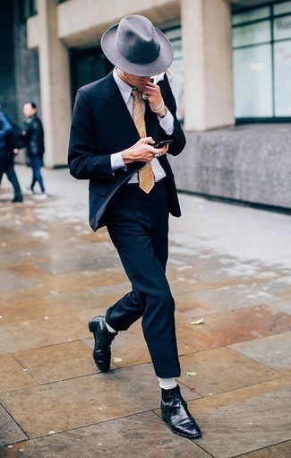 Come indossare e abbinare una cravatta beige quando fa caldo: Indossa un abito blu scuro con una cravatta beige come un vero gentiluomo. Se non vuoi essere troppo formale, opta per un paio di stivali eleganti in pelle neri.