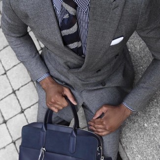 Come indossare e abbinare una ventiquattrore blu scuro per un uomo di 30 anni: Per un outfit quotidiano pieno di carattere e personalità, potresti combinare un abito grigio con una ventiquattrore blu scuro.