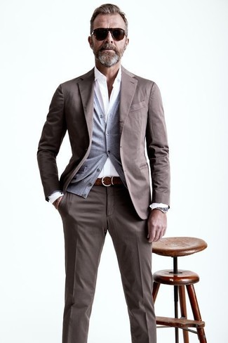 Come indossare e abbinare un abito marrone scuro per un uomo di 50 anni in modo smart-casual: Potresti indossare un abito marrone scuro e un cardigan grigio per una silhouette classica e raffinata