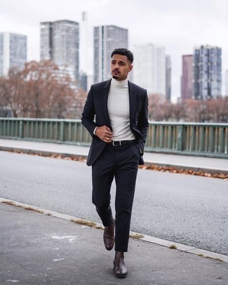 Moda uomo anni 20 in modo formale: Indossa un abito blu scuro e un dolcevita bianco per un look elegante e di classe.