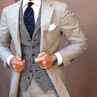 Look alla moda per uomo: Abito di lana grigio, Gilet con motivo pied de poule bianco e nero, Camicia elegante bianca, Cravatta a pois blu scuro