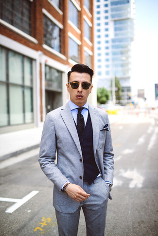 Come indossare e abbinare un abito di lana grigio per un uomo di 20 anni: Abbina un abito di lana grigio con un gilet a righe verticali blu scuro per un look elegante e di classe.