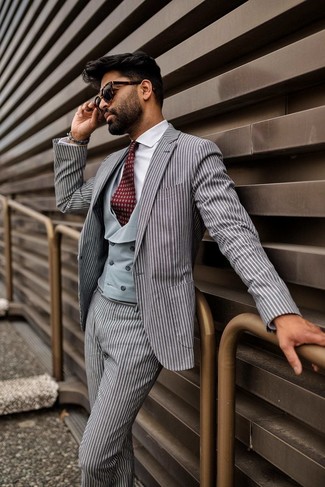 Come indossare e abbinare una cravatta stampata rossa in autunno 2024: Opta per un abito a righe verticali grigio e una cravatta stampata rossa come un vero gentiluomo. Una buona scelta per un outfit autunnale!