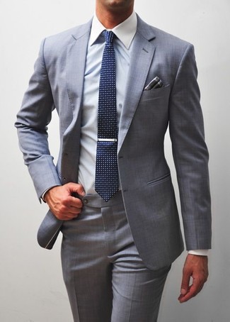 Look alla moda per uomo: Abito grigio, Camicia elegante bianca, Cravatta stampata blu scuro, Fazzoletto da taschino scozzese grigio