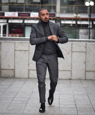 Come indossare e abbinare un maglione grigio scuro per un uomo di 30 anni: Mostra il tuo stile in un maglione grigio scuro con un abito grigio scuro per un look elegante e di classe. Impreziosisci il tuo outfit con un paio di scarpe derby in pelle nere.