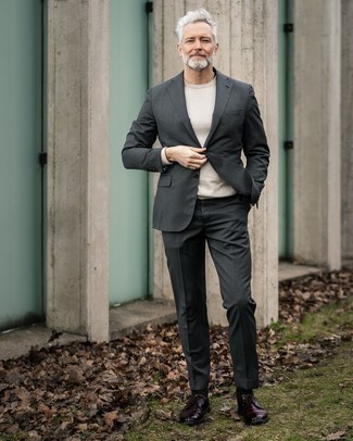Come indossare e abbinare un abito grigio per un uomo di 50 anni: Abbina un abito grigio con un maglione girocollo bianco per una silhouette classica e raffinata Scarpe derby in pelle bordeaux sono una valida scelta per completare il look.