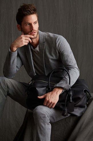 Come indossare e abbinare un borsone in pelle nero in estate 2024 in modo smart-casual: Scegli un outfit composto da un abito grigio e un borsone in pelle nero per vestirti casual. L'outfit per l’estate è servito.