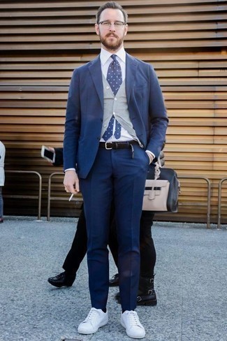 Come indossare e abbinare una cravatta a pois blu quando fa caldo: Coniuga un abito blu scuro con una cravatta a pois blu come un vero gentiluomo. Per un look più rilassato, prova con un paio di sneakers basse di tela bianche.