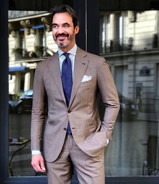 Come indossare e abbinare una cravatta blu scuro per un uomo di 50 anni in estate 2024: Prova ad abbinare un abito marrone con una cravatta blu scuro per un look elegante e di classe. Ecco un look indispensabile per questa estate.