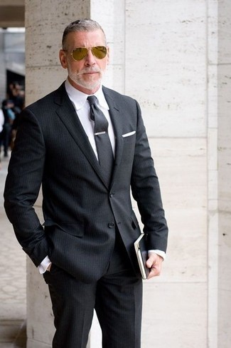 Come indossare e abbinare una cravatta grigio scuro per un uomo di 50 anni quando fa caldo: Scegli uno stile classico in un abito a righe verticali nero e una cravatta grigio scuro.