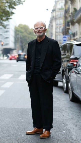 Moda uomo anni 50: Coniuga un abito nero con una t-shirt girocollo nera per un drink dopo il lavoro. Scegli uno stile classico per le calzature e mettiti un paio di mocassini eleganti in pelle terracotta.