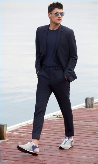 Come indossare e abbinare scarpe sportive grigio scuro per un uomo di 30 anni quando fa caldo in modo smart-casual: Prova a combinare un abito blu scuro con una t-shirt girocollo blu scuro, perfetto per il lavoro. Prova con un paio di scarpe sportive grigio scuro per avere un aspetto più rilassato.