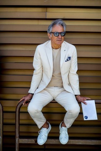 Quale sneakers basse indossare con un abito bianco per un uomo di 60 anni in modo smart-casual: Indossa un abito bianco con una t-shirt girocollo beige per un abbigliamento elegante ma casual. Prova con un paio di sneakers basse per avere un aspetto più rilassato.