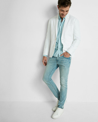 Come indossare e abbinare jeans azzurri per un uomo di 20 anni in modo smart-casual: Potresti indossare un blazer bianco e jeans azzurri per un look davvero alla moda. Per distinguerti dagli altri, scegli un paio di sneakers basse in pelle bianche.
