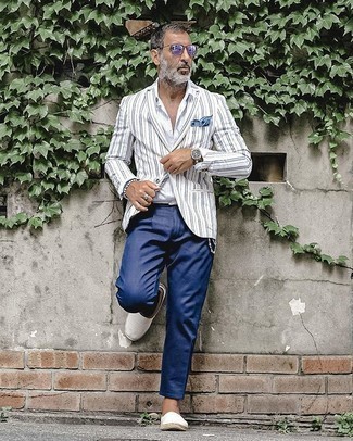 Come indossare e abbinare un blazer bianco e nero per un uomo di 50 anni: Metti un blazer bianco e nero e chino blu scuro per creare un look smart casual. Per un look più rilassato, scegli un paio di espadrillas di tela bianche.