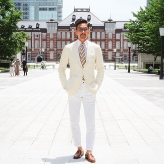 Come indossare e abbinare un blazer beige: Coniuga un blazer beige con chino bianchi per creare un look smart casual. Scegli un paio di mocassini eleganti in pelle marroni per dare un tocco classico al completo.