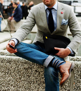 Come indossare e abbinare un blazer di lana grigio con jeans blu scuro: Prova a combinare un blazer di lana grigio con jeans blu scuro, perfetto per il lavoro. Completa il tuo abbigliamento con un paio di scarpe derby in pelle marrone chiaro.
