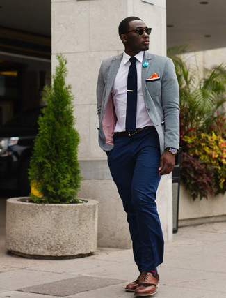 Quale blazer indossare con scarpe brogue marroni: Scegli un blazer e pantaloni eleganti blu scuro per essere sofisticato e di classe. Per un look più rilassato, mettiti un paio di scarpe brogue marroni.