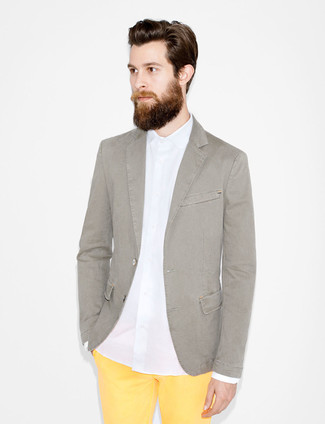 Come indossare e abbinare chino gialli con un blazer grigio: Scegli un outfit composto da un blazer grigio e chino gialli per creare un look smart casual.