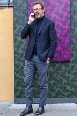 Come indossare e abbinare stivali neri per un uomo di 40 anni: Abbina un blazer blu scuro con chino grigi, perfetto per il lavoro. Stivali neri sono una gradevolissima scelta per completare il look.
