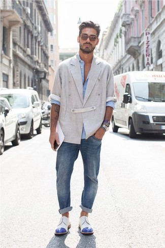 Quale blazer doppiopetto indossare con jeans blu scuro: Combina un blazer doppiopetto con jeans blu scuro se cerchi uno stile ordinato e alla moda. Opta per un paio di scarpe derby in pelle bianche e blu per un tocco virile.
