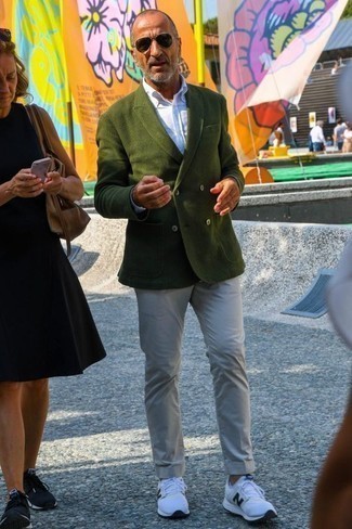 Come indossare e abbinare un blazer verde scuro per un uomo di 50 anni: Potresti combinare un blazer verde scuro con chino beige, perfetto per il lavoro. Per distinguerti dagli altri, scegli un paio di scarpe sportive bianche e nere come calzature.