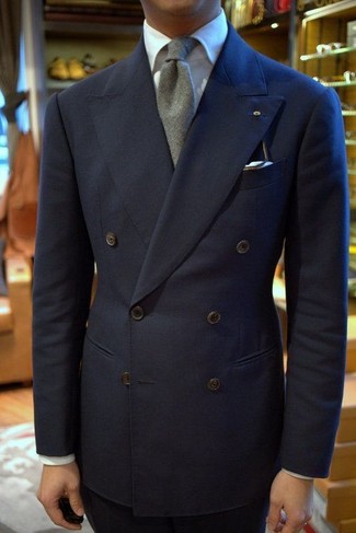 Come indossare e abbinare una cravatta di lana grigia in modo formale: Vestiti con un blazer doppiopetto blu scuro e una cravatta di lana grigia per una silhouette classica e raffinata