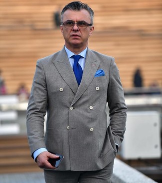 Look alla moda per uomo: Blazer doppiopetto grigio, Camicia elegante azzurra, Pantaloni eleganti grigi, Cravatta lavorata a maglia blu