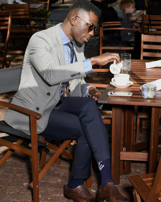 Come indossare e abbinare un blazer doppiopetto grigio: Mostra il tuo stile in un blazer doppiopetto grigio con pantaloni eleganti blu scuro per una silhouette classica e raffinata Scarpe brogue in pelle marroni daranno una nuova dimensione a un look altrimenti classico.