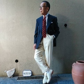 Moda uomo anni 60: Prova a combinare un blazer doppiopetto blu scuro con pantaloni eleganti beige per essere sofisticato e di classe. Scegli un paio di scarpe brogue in pelle scamosciata bianche per avere un aspetto più rilassato.